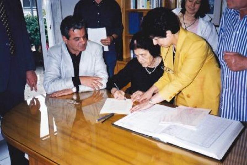 Η μεγάλη ευεργέτης της πόλεως στις 23 Μαΐου 2003 υπογράφει την δωρεά στο Δήμο Πτολεμαϊδας (φωτογραφία απο το αρχείο του Γρ. Τσιούμαρη).
